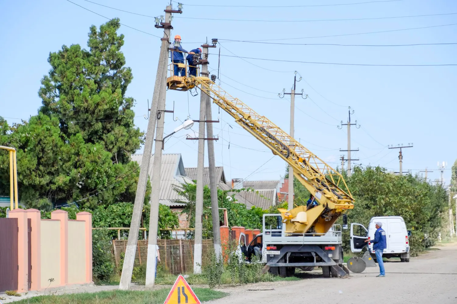 Bucket truck crew performing clearing near power lines.
