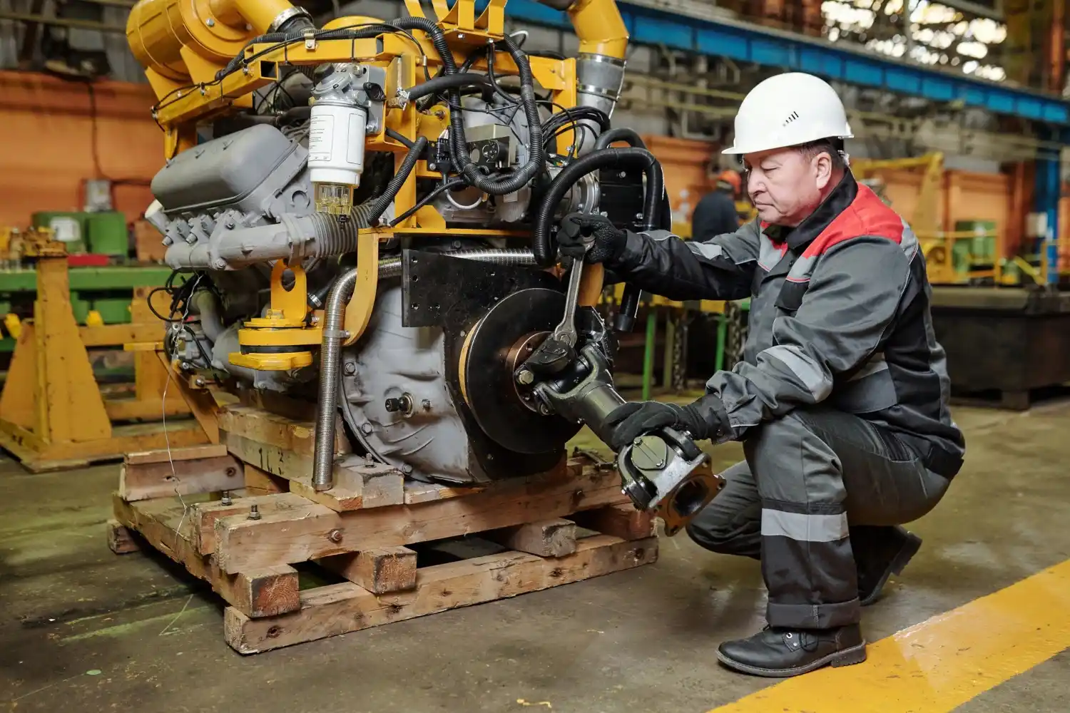 Technician performing heavy equipment maintenance on a diesel engine