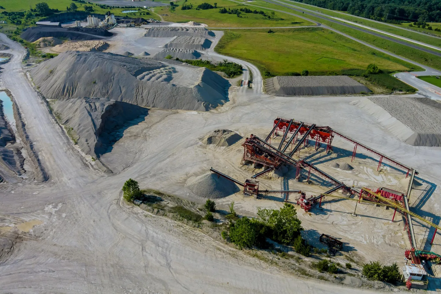 Aerial view of a grading and excavation site with material stockpiles
