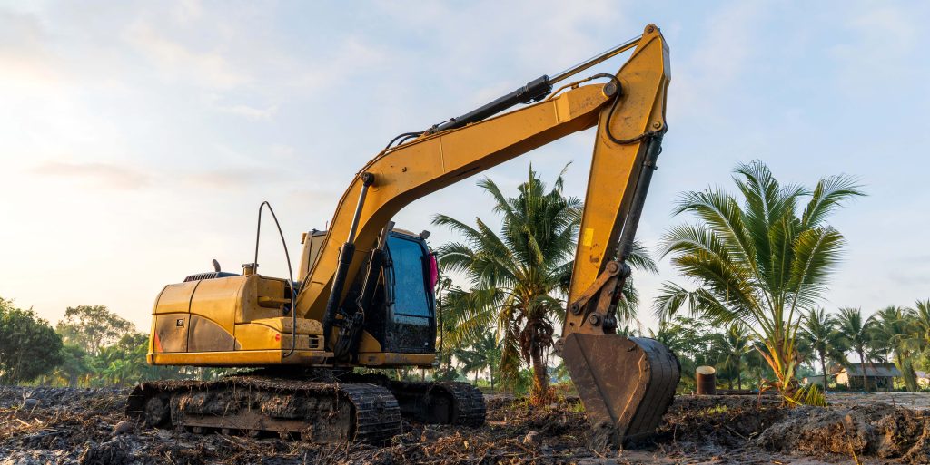 Excavator parked before work in morning sunlight in excavation t
