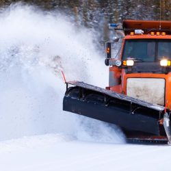 an orange truck with a snow plow on the front