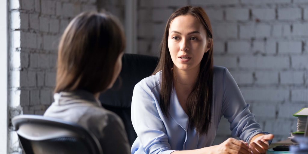 Serious professional female advisor consulting client at meeting