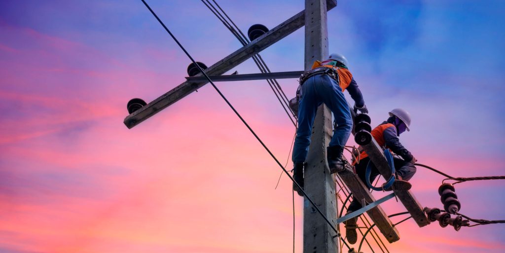 Electrician lineman repairman worker at climbing work on electri