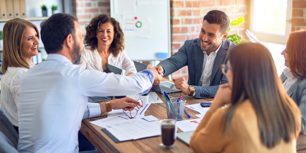 Group of business workers smiling happy and confident. Working together with smile on face shaking hands at the office Group of business workers smiling happy and confident. Working together with smile on face shaking hands at the office