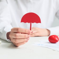 someone in a white shirt holding a small red umbrella