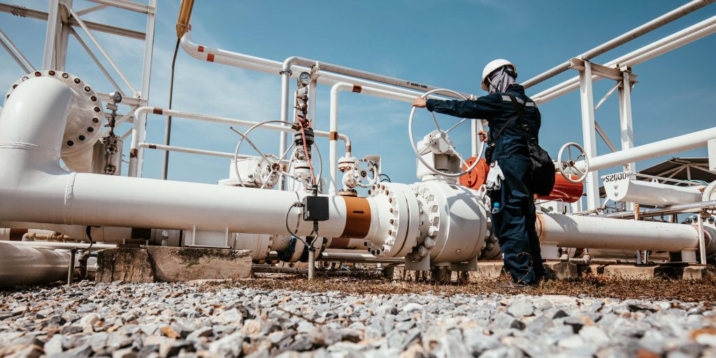 Production operator opening ball valve at pipeline oil and gas w