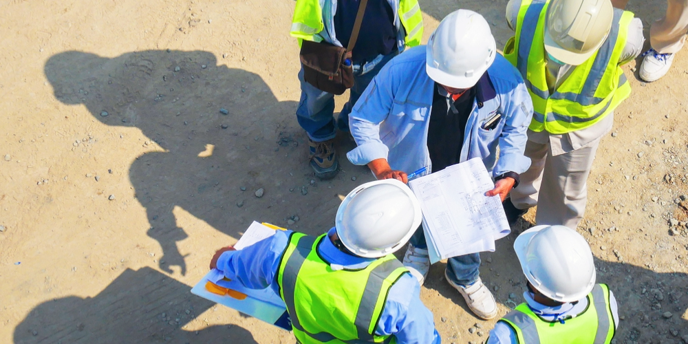 General contractor and subcontractors reviewing plans on a construction job site, highlighting subcontractor liability exposures