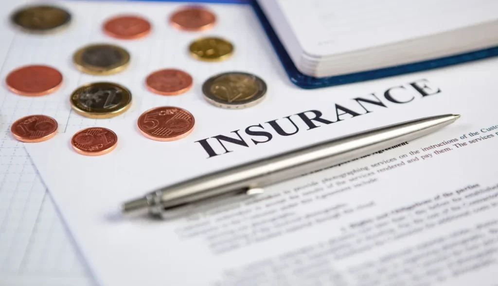 Pen resting on a high deductible vs low deductible insurance contract