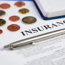 Pen resting on a high deductible vs low deductible insurance contract
