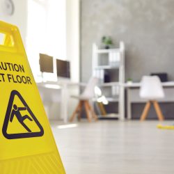 Janitor mopping floor with caution sign