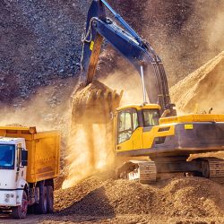 Excavator dumping dirt into a dump truck