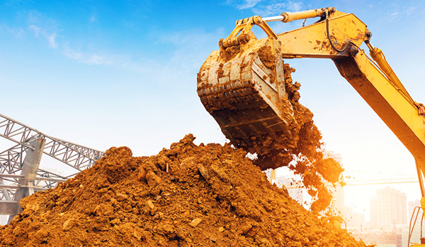 excavator-dumping-dirt-600x350 Close up of excavator piling earth