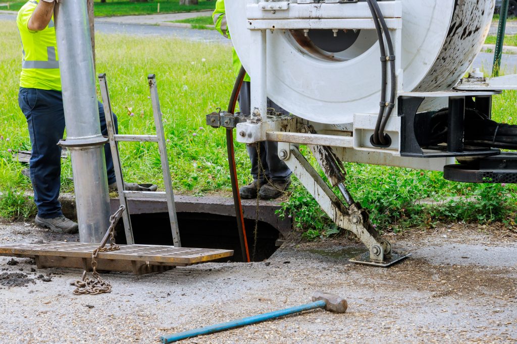 Machine for cleaning sewer wells in the a town street.