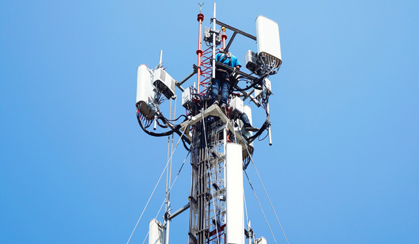 shutterstock_1911048943 Utility contractors repairing cell tower