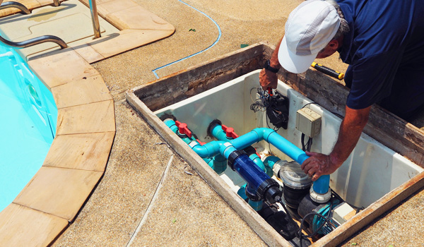 shutterstock_1944941344 Pool contractor servicing pool plumbing