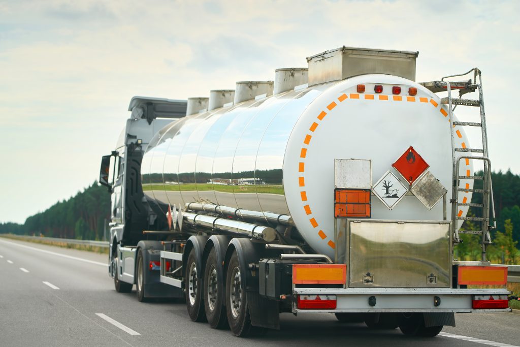 Truck hauling hazardous liquid cargo down road