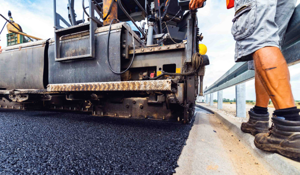 worker-road-compactor-600x350 Asphalt worker walking behind road compactor