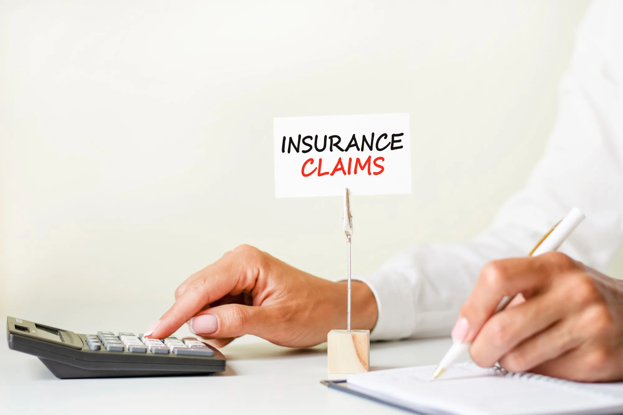 Business owner calculating costs while filing an insurance claim